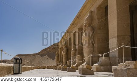 Dilapidated Sculptures Of Pharaohs Stand In A Row Along The Colonnade On The Terrace Of The Funeral 