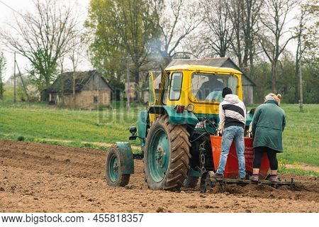 Preili, Latvia - May 14 2022: Plowing And Sowing The Soil With An Old Farm Tractor Belarus In An Agr