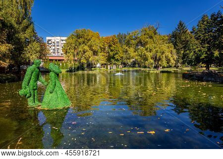 Razlog, Bulgaria - October 20, 2020: Lake, Man And Woman Green Leafs Figurines Panoramic View With A