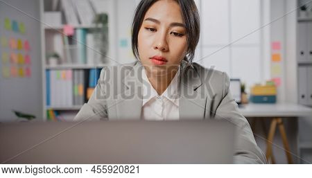 Young Asian Businesswoman Sit On Desk With Laptop Overworked Tired Burnout Syndrome At Office. Exhau