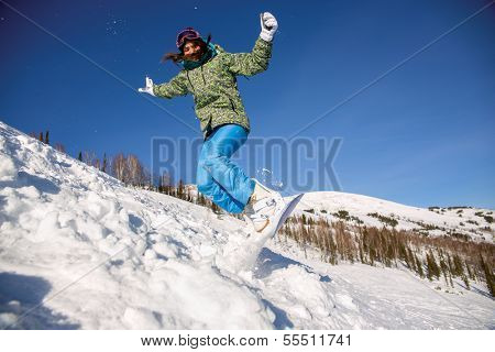 Snowboarder jumping through air with deep blue sky in background