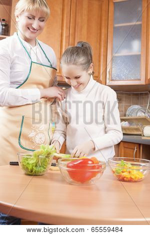 Young Caucasian Female Blond Teaching Her Daughter To Cook