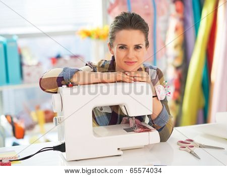 Portrait Of Happy Seamstress With Sewing Machine