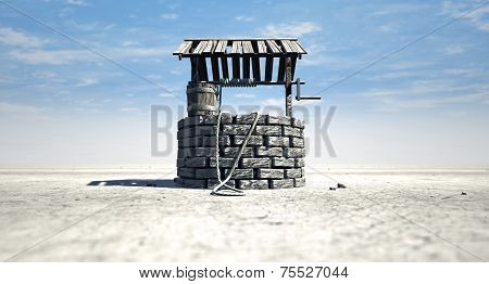 Wishing Well With Wooden Bucket On A Barren Landscape
