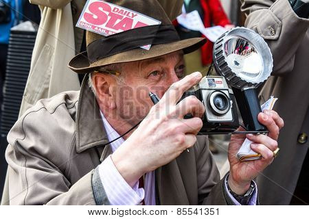 A fake paparazzi pretends to take a picture