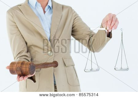 Young woman holding scales of justice and a gavel on white background