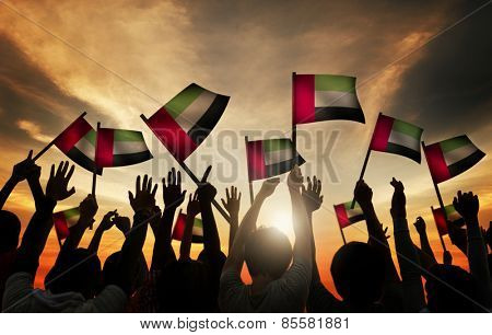 Group of People Waving Flag of UAE in Back Lit