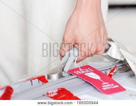 Man Holding Suitcase With Luggage Tag (fragile) At Airport