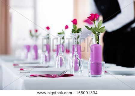 Male Waiter Placing Napkin On Wedding Table