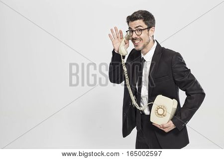 Studio portrait of an expressive man of the 70s talking on a classic phone