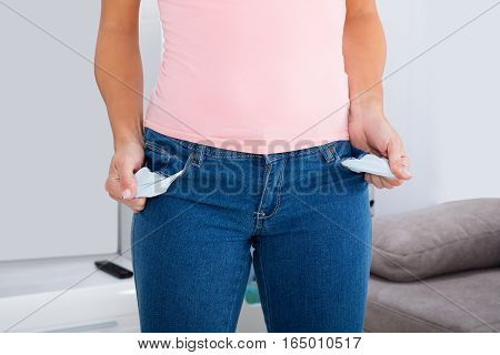 Close-up Of Young Woman Showing Empty Pocket At Home