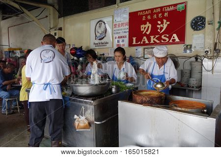 Hawker Vendor At Their Assam Laksa Noodle Stall In Air Itam, Penang