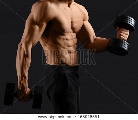 Iron pump. Cropped closeup of a muscular man working out with dumbbells showing off his perfect sexy torso