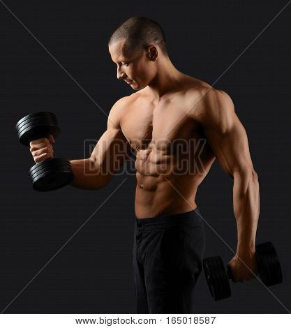 Ironman. Young handsome bodybuilder showing off his sexy ripped body working out with weights