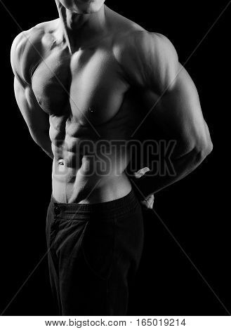 Such a body takes work. Monochrome cropped shot of a sexy ripped muscular man posing in studio showing off his abs