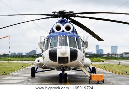 Detail with helicopter fuselage and rotor blade system on runway