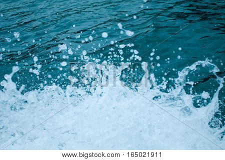 Water splashing. Crystal clear sea water beating against the boat.