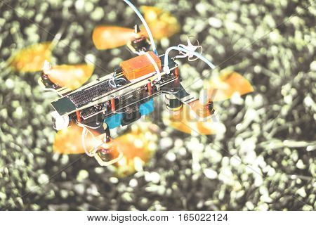 Intellingent speed drone hovering on a blurred grass of a park - Colorful new racer technologys of smart quadcopter flying tests - Black and white background
