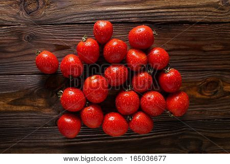 Red tomatoes with water drops. Tomatoes of different varieties. omatoes background. Fresh tomatoes Healthy food concept. Colorful festive still life. Loosely laid tomatoes in different positions.