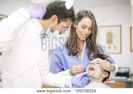 Young Man Having Dental Chekup At Dentist Office