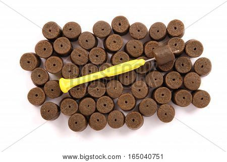 Brown pre-drilled halibut pellets for carp fishing Isolated on white background with soft shadow