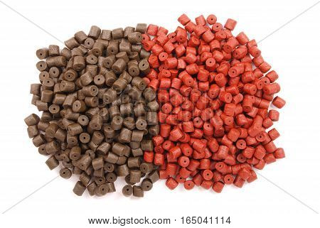Brown with red pre-drilled halibut pellets for carp fishing isolated on white background with soft shadow