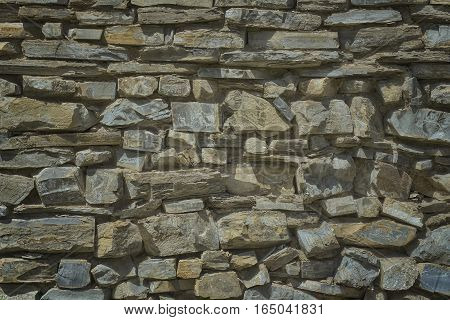 The facade is made of natural stone gray