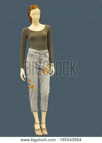Full-length female mannequin dressed in jumper and blue jeans isolated. No brand names or copyright objects.