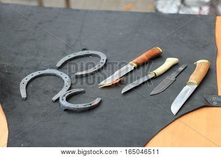 knives and horseshoes on the table in forge