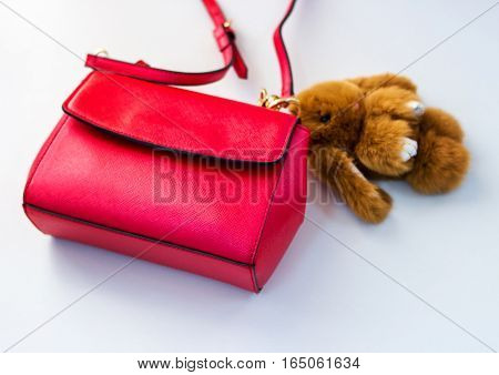 Red ladies handbag ladies handbag with a soft toy.