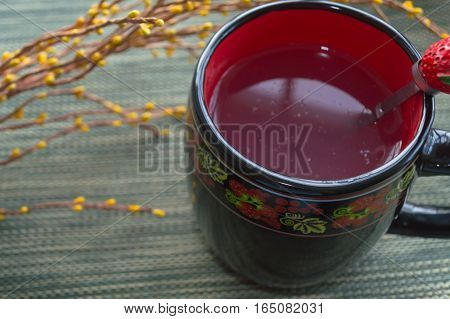 kissel in mug with yellow branch of artificial flowers
