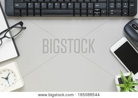 Desk above table top view of office desk with notebook pen clock keyboard and mouse on grey background