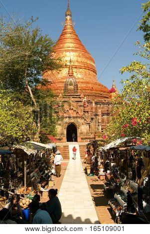 Bagan Myanmar - 24 January 2010: People on the street with gift shops in front of Dhammayazika pagoda at the archaeological site of Bagan on Myanmar
