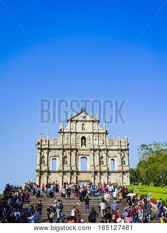 Macao China - December 9 2016: Tourists and local residents walk pass and take photos at The Ruins of St. Paul's in sunny day crowded tourist in blue sky sunny day