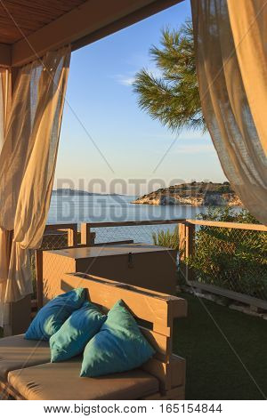 Summertime relax.The most beautiful coasts of Italy: bay of Vieste.-(Apulia, Gargano) -In the foreground the Gattarella or Portonuovo Islet and in the background the town of Vieste.Seascape at sunset sitting on a couch.