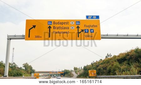 VIENNA AUSTRIA - SEP 30 2014: Driver POV point of view orange street sign on highway to Budapest Bratislava Fischamend Flughafen Airport on Austrian highway autobahn