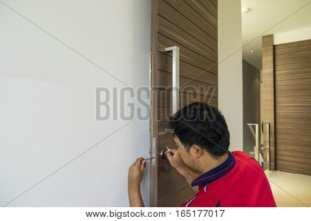 locksmith use screwdriver repair the wood door - can use to display or montage on product