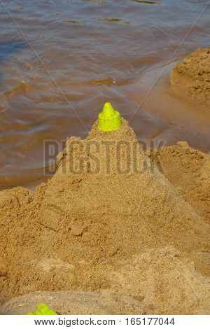 building the sandcastle on the beach near the river