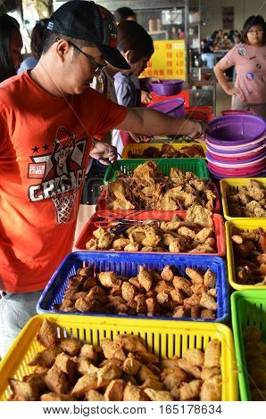 IPOH MALAYSIA- 28 DEC 2016: Customer selects different fish paste cake in locat stall in Ipoh Malaysia