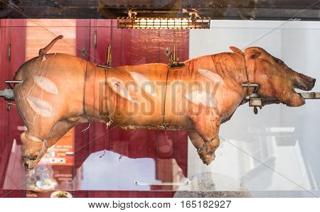 roasted juicy pig spinning on the spit