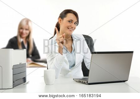 Two young women working in the office on their laptops