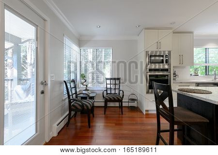 Modern kitchen and dining room interior with stainless steel appliances in a luxury house.
