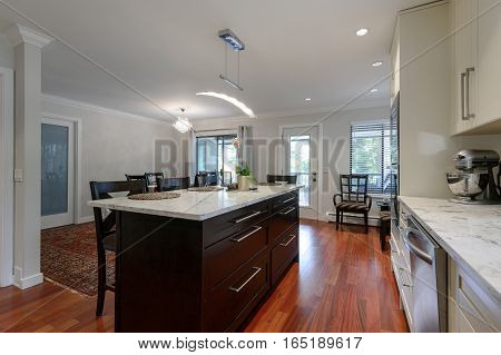 Modern kitchen and dining room interior with stainless steel appliances in a luxury house.