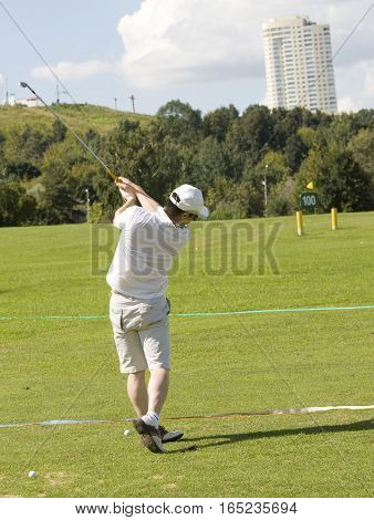 MOSCOW - AUGUST 17 2013: man plays golf on golf-fields in sport complex Krylatskoye in region Krylatskiye hills.
