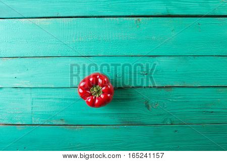 Red bell pepper on a wooden turquoise background. Top view Copyspace