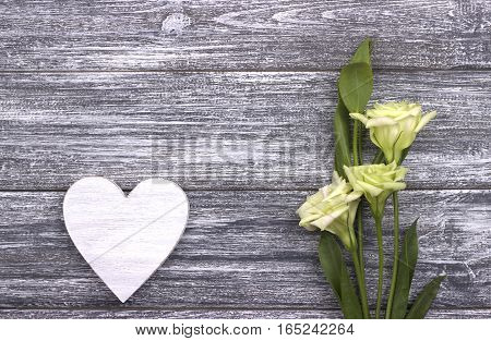 Decorative white wooden heart on gray wooden background with copy space flowers. Valentines day card concept. Love. Wedding