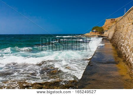 Rethymnon Island Crete Greece - July 1 2016: View on Leoforos Emmanouil Kefalogianni embankment and sea with clear emerald water.