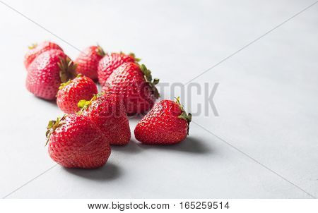 Fresh strawberry on gray background . Red strawberry. Loosely laid strawberries in different positions. Copyspace.