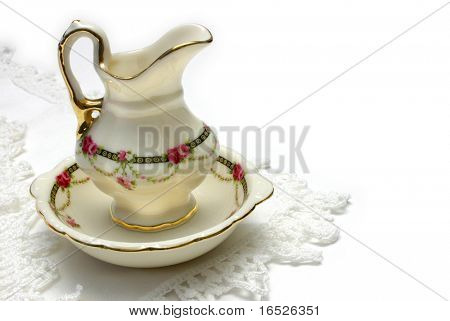 Bacia de lavagem de estilo antigo em miniatura e jarra em crochê com arestas de linho, isolado no branco