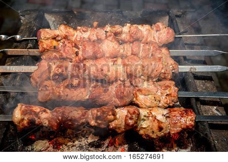 Cooking barbecue dish named shashlyk using skewers on mangal